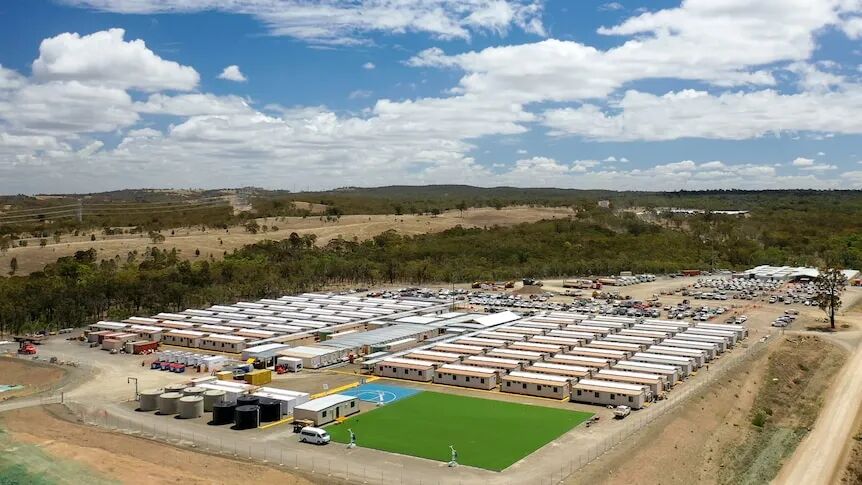 Rows of demountable buildings in an outback area, as seen from above.